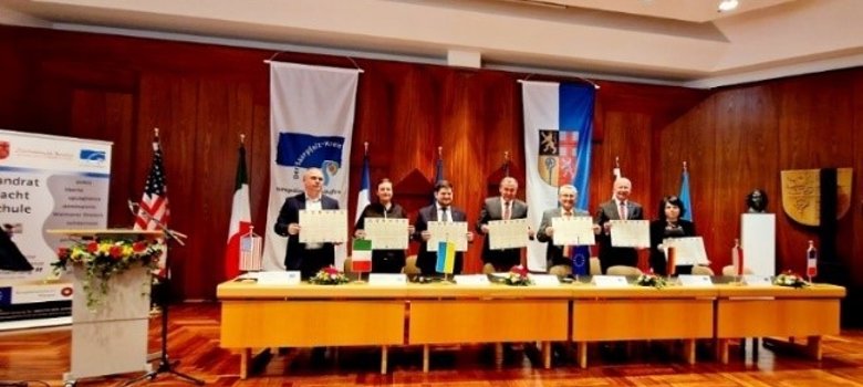 Signing the certificate of the International Museum Alliance, those responsible hold up the certificate