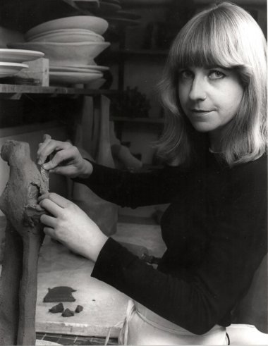 Black and white photo of a woman working on a sculpture.
