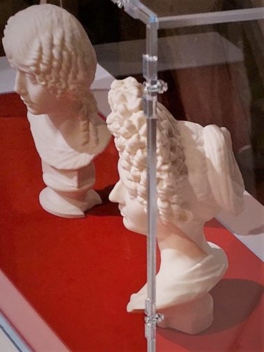 Photo of a display case with two bust replicas.