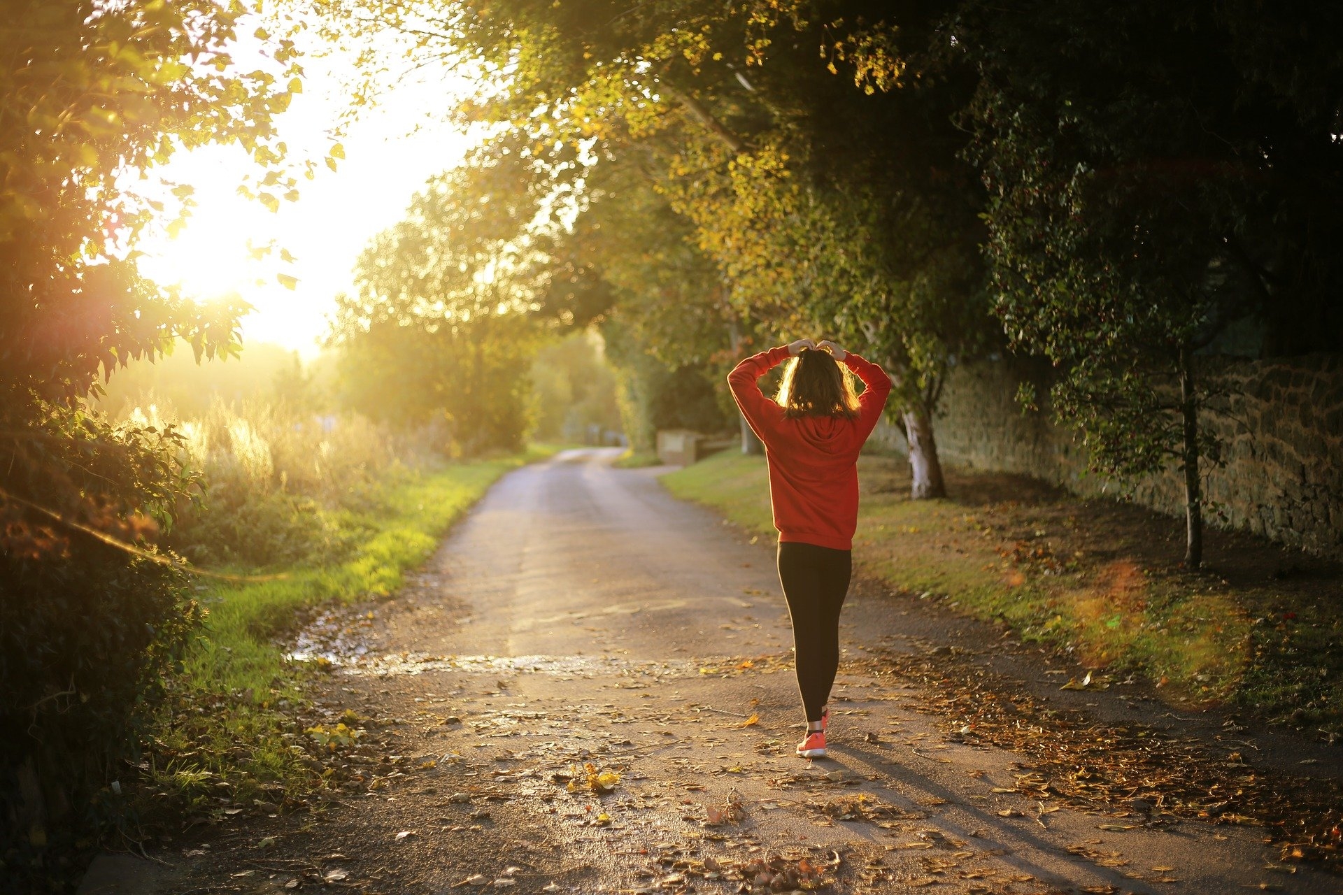 A woman catches her breath on a forest path