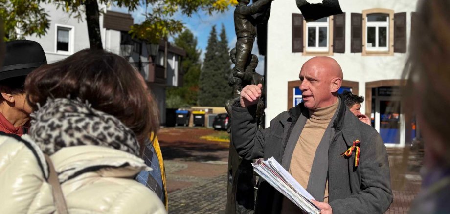 Klaus Friedrich explique à la Fontaine de la Liberté de Hombourg sa symbolique par rapport au Vormärz et à la chute du Mur en 1989, ainsi que les références américaines qui y sont liées, photo : Beate Ruffing Klaus Friedrich explique à la Fontaine de la Liberté de Hombourg sa symbolique par rapport au Vormärz et à la chute du Mur en 1989, ainsi que les références américaines qui y sont liées, photo : Beate Ruffing