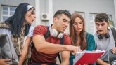 un jeune homme montre quelque chose sur un bloc à trois autres personnes