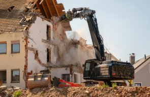 Démolition de bâtiments Démolition d'une maison à l'aide d'une pelleteuse