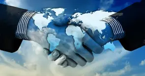 Une main qui en serre une autre, une image de carte du monde.