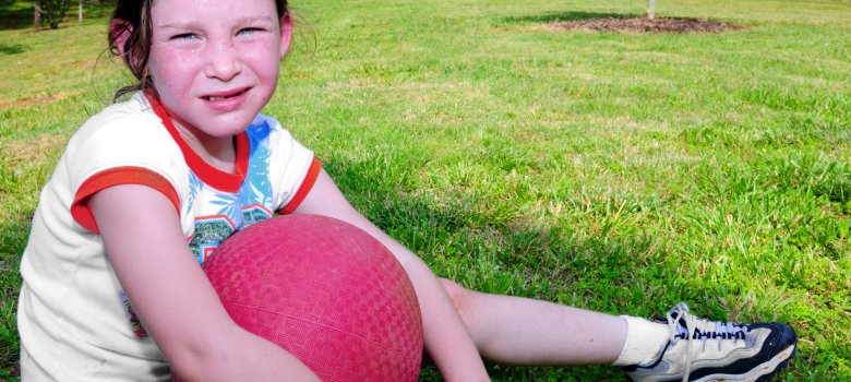 Jeune fille tenant un ballon, l'air épuisée, en sueur et à bout de forces après Jeune fille tenant un ballon, l'air épuisée, en sueur et à bout de forces après