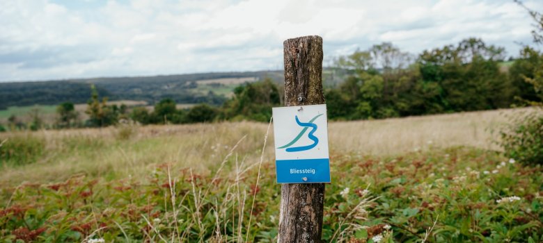 Projet LEADER Gestion des sentiers touristiques Signalisation du Bliessteig sur un poteau en bois dans une zone rurale
