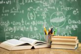 Tavolo con diversi libri e penne e una lavagna sullo sfondo