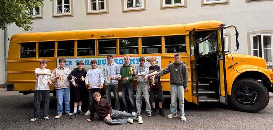 Autobus Bana z uczniami klasy 8 na podwórku szkolnym Von der Leyen-Gymnasium w Blieskastel. Żółty autobus szkolny z uczniami