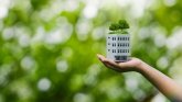 Budynki neutralne dla klimatu Ręka trzymająca model domu z lasem na dachu