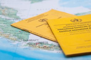 Dwa paszporty szczepień leżą na mapie świata