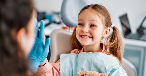 Zdrowie zębów u dzieci i młodzieży Uśmiechnięte dziecko u dentysty