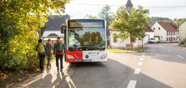 Автобус останавливается на автобусной остановке, и люди садятся в него