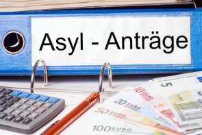 Sığınmacılar için yardımlar Arka planda sığınma başvurularının, ön planda ise banknot ve hesap makinelerinin bulunduğu bir klasör