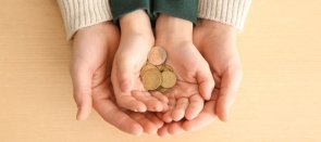 Bozuk para tutan bir çocuğun ellerini tutan yetişkin eller