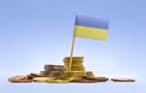 Допомога біженцям з України Прапор України стоїть у невеликій купі монет