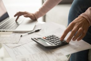 Оскарження Права рука друкує на ноутбуці, ліва - на калькуляторі