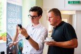 Підліток показує чоловікові щось на мобільному телефоні