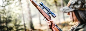Полювання Жінка з гвинтівкою та в камуфляжному одязі