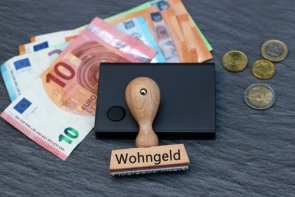 Wohngeld Geldscheine, Münzgeld und ein Stempel mit Aufdruck Wohngeld