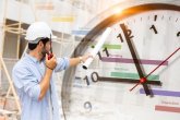 Informationen zur Vergabe Ein Mann mit einem Helm zeigt auf Uhr mit Ablaufsplan