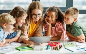 Eine Frau zeigt Kindern etwas auf einem Tablet