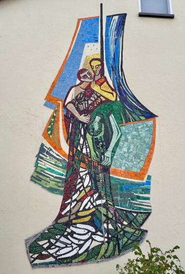 Helene Trossen Mosaik Farbfoto eines Mosaiks an einer Außenwand, welches drei Fischer mit einem Netz voller Fische darstellt.