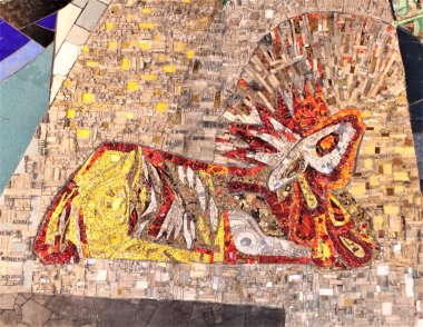 Lamm Gottes Ausschnitt Buntes Mosaik, welches ein liegendes Lamm, umrandet von Flammen, zeigt.