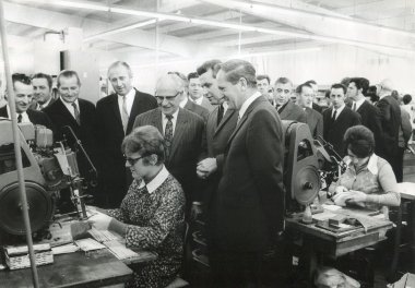 Inbetriebnahme der Fabrik Dorndorf Schwarz-Weiß Foto einer Fabrikhalle von innen mit arbeiteten Frauen und Politikern.