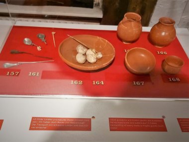 Foto einer Vitrine mit Objekten eines gehobeneren Gastmahls.