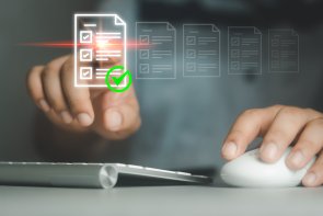 Hände tippen auf einer Tastatur und virtuelle Zeichen für Dokumente sind oben drüber zu sehen