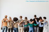 Ausbildung und Studium Eine Reihe von Menschen stehen mit dem Rücken zur Kamera nebeneinander und haben die Arme über die Schultern gelegt