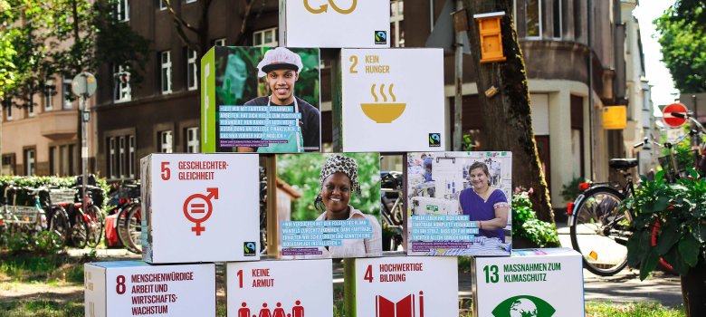 Fairtrade und die UN-Nachhaltigkeitsziele Blöcke zu einer Pyramide gestellt mit Zielen der Fairtrade-Kampagne und Zitaten von Betroffenen, denen dadurch geholfen