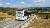 Fahrender Bus von hinten auf einer Landstraße 